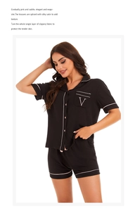 Detail of black modal pajamas set featuring contrast piping and V-letter embroidery on pocket