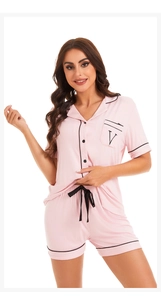 Detail of light pink modal pajamas set with black piping and embroidered chest pocket V
