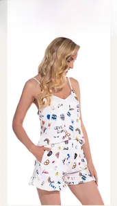 Details des weißen Baumwoll-Pyjama-Sets mit bunten Comic-Prints und Rüschen am Saum