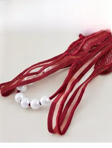 Détail de lingerie en dentelle rouge avec perles blanches élégantes sur les brides