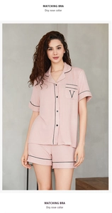Détail de l'ensemble pyjama rose sec avec passepoil noir et broderie de poche V