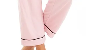 Detail of pink modal pajama pants featuring black piping trim and soft fabric texture