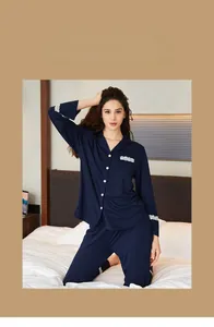 Detail of dark blue knit pajamas featuring elegant white lace trim on cuffs and pocket