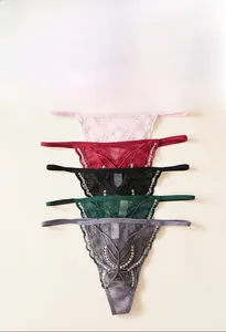Détail de cinq strings en dentelle avec broderie de papillon à paillettes sur tissu mesh