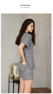 Détail d'un ensemble homewear en maille côtelée grise avec liseré rose et broderie V
