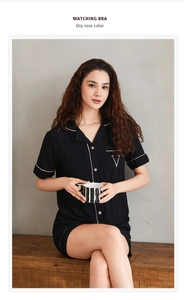 Détail du pyjama modal noir à rayures avec liseré rose et broderie V sur la poche