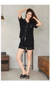 Détail de l'ensemble de pyjama noir en modal avec passepoil blanc et broderie sur la poche