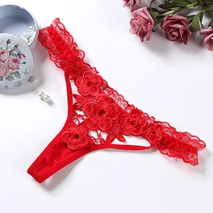 String sexy en dentelle rouge avec broderie florale sur un fond blanc romantique