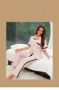 Détail du pyjama en modal rose avec rayures marine, broderie V et texture côtelée