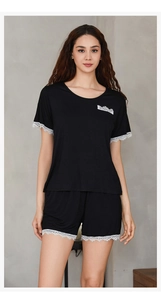 Detail of white lace trimming on the cuffs and hem of this black modal pajama set
