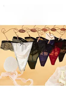 Gros plan de strings en dentelle à pois et nœuds en six couleurs sur cintres