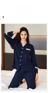 Detail of dark blue pajama set featuring elegant white lace trim on sleeves and pockets