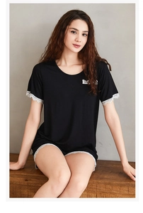Close-up of black modal pajama set featuring elegant white lace trim on sleeves and hem