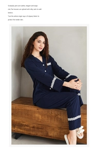 Close-up of elegant white lace trim on navy blue long-sleeved pajamas with silky texture