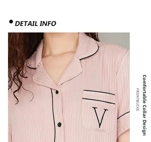 Détail du pyjama en modal rose avec revers classique, passepoil contrasté et poche poitrine