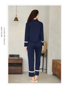 Detail of white floral lace trim on navy blue knit sleeves and hem of the pajama set