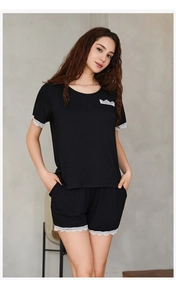 Close-up of black modal pajamas with delicate white lace trim on sleeves and shorts