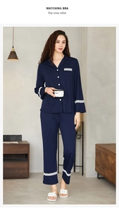 Detail of navy blue knit cotton pajama set featuring intricate white lace trim on sleeves