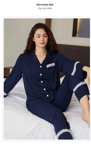 Close-up of elegant white lace detailing on the cuffs and collar of dark blue pajamas