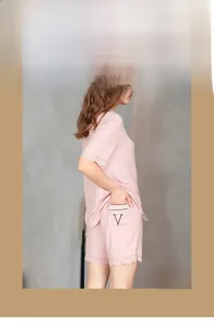 Detail of pink loungewear set showing lace trim on sleeves and V-shaped embroidery