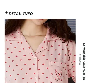 Detail des rosa Pyjama-Revers mit Herzmuster und rot bestickter Brusttasche