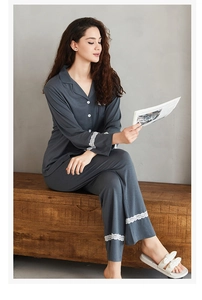 Detail of dark grey knit pajama set showing white lace trim on sleeves and pant cuffs