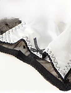 Gros plan détaillé d'un string en maille blanche avec nœud noir et dentelle fine