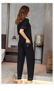 Detail of modal pajama cuffs and hem with pink piping and white letter V embroidery