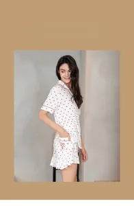 Detail of red heart polka dot pajamas with shirt collar and ruffle trim on the hem