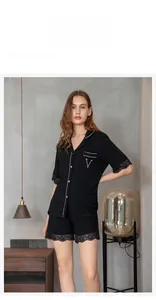 Detail of black modal pajama set featuring lace trim and pink contrast piping