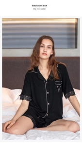 Detail shot of black modal pajamas set featuring delicate lace trim and pink piping accents
