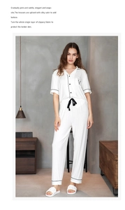 Detail of white striped modal pajama set with black piping and embroidered pocket V