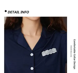 Detail of dark blue knit pajama top featuring a soft lapel collar and lace pocket trim