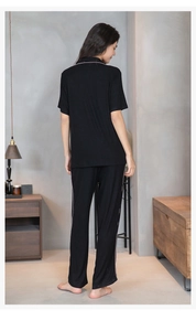 Détail du pyjama en modal noir rayé avec passepoil rose et texture verticale dans le dos