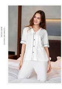 Detail of modal striped pajama top with V-embroidery on pocket and elegant black piping