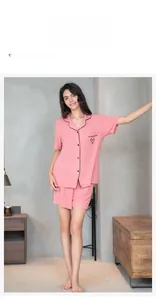 Detail view of pink modal pajamas with heart embroidery and black contrast piping