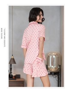 Detail of pink modal pajama set with red heart prints and ruffled hem on shorts