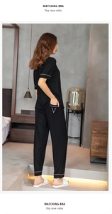 Detail of modal striped pajamas with contrast piping and 'V' embroidery on the pocket