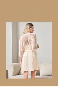 Dettaglio vestaglia in pizzo beige e sottoveste in seta con cintura in raso