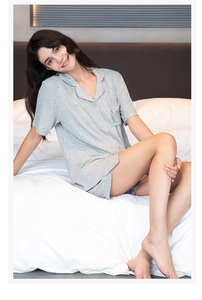 Close-up of gray modal pajamas with pink piping and heart embroidery on the pocket