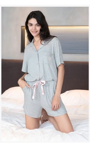 Close-up of ribbed gray pajama shorts with pink silk bow and delicate heart pocket detail