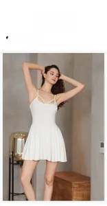 Détail d'une nuisette blanche en maille à fines bretelles et ourlet plissé élégant