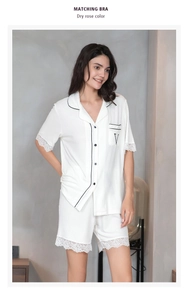 Detail of white modal sleepwear set featuring contrast piping and delicate lace trim on cuffs