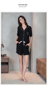Detail view of black pajamas set with white piping and pink satin waist drawstring
