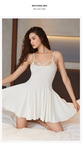 Détail d'une nuisette blanche en coton avec fines bretelles croisées et ourlet plissé