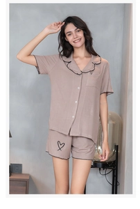 Vue détaillée du pyjama en modal rose avec bords noirs volantés et broderie cœur