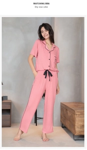 Détail de pyjama rose poudré avec broderie cœur et taille à nœud noir élégant