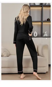 Détail de la lettre V rose brodée sur la poche du pantalon de pyjama noir rayé