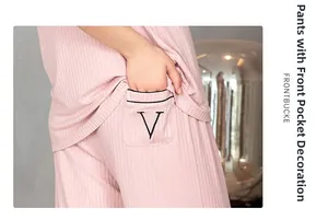 Detail of pink striped pajama pants featuring a side pocket with contrast black trim and V print
