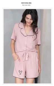 Détail du vêtement de détente rose séché montrant la broderie cœur et le coton nervuré